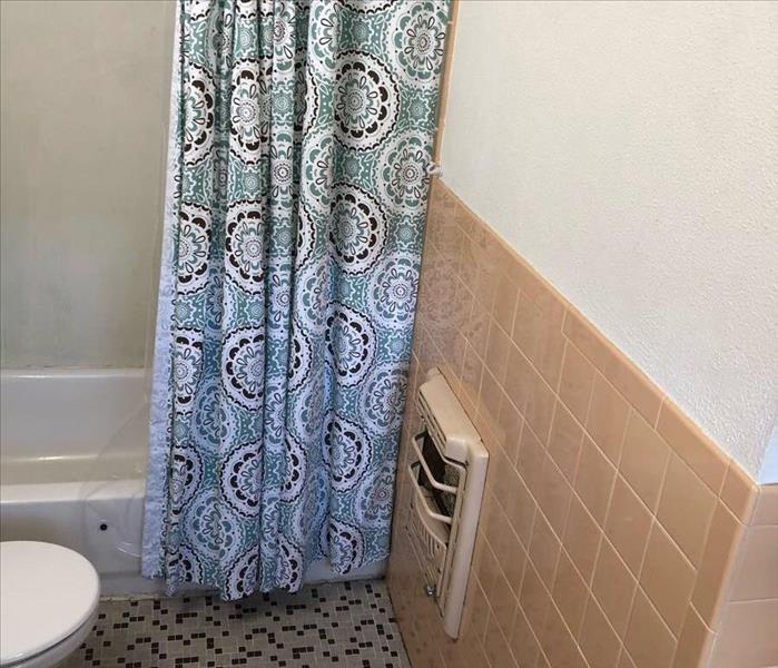 bathroom with damaged back wall, shower curtain